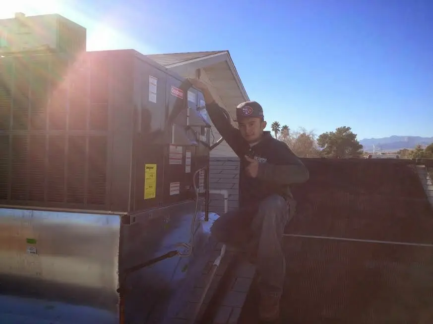 HVAC technician performing AC Tune-Up on a rooftop unit in Little Elm
